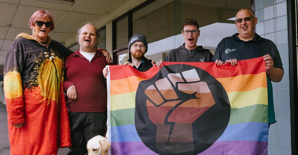 Rainbow united members holding flag