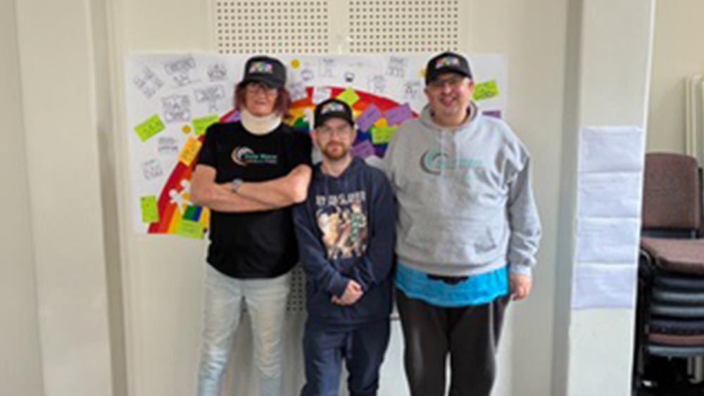 Rainbow united members during the logo and website co-design session standing in front of ideas board